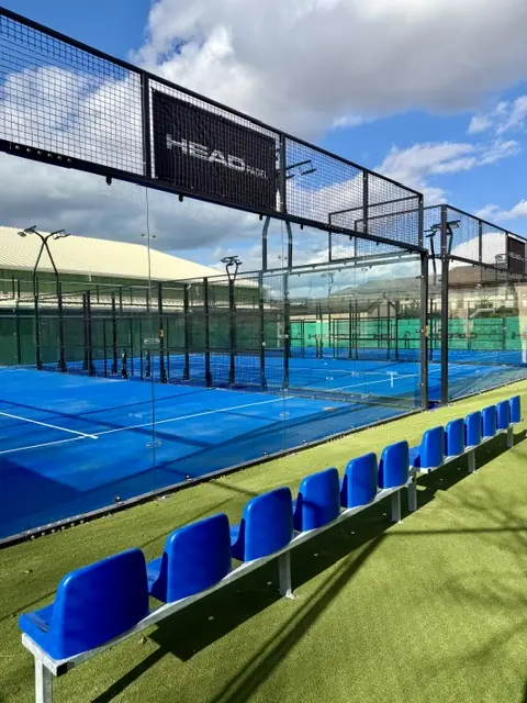 Panoramatický padelový kurt v Sportcentre MB v Mladej Boleslavi a rad sedadiel pre divákov na umelom trávniku