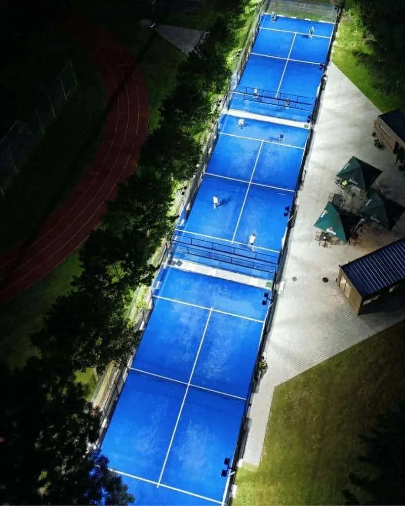 Letecký pohľad na tri osvetlené vonkajšie padelové kurty Padel Point na Gemerskej ulici v Žiline v noci